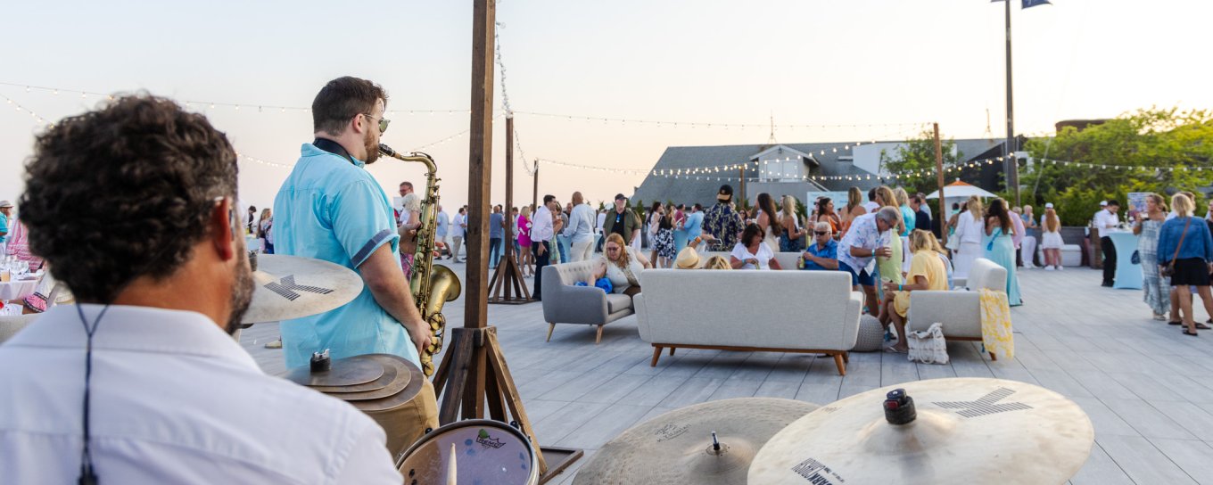 A band plays in the foreground with people in the background at Gurney's Montauk