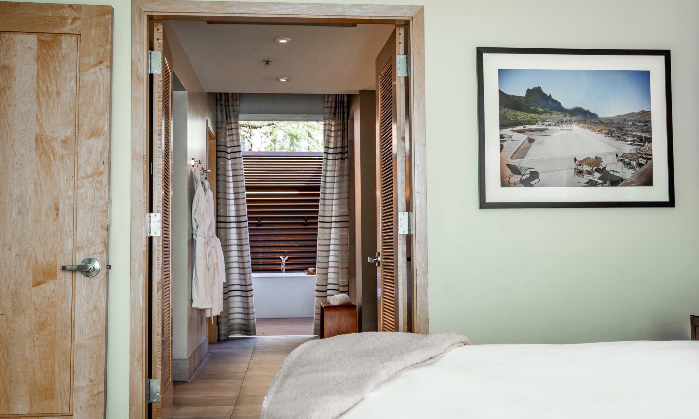 View from bed through bathroom to outdoor soaking tub.