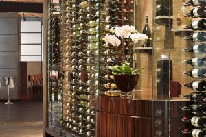 Elements wine wall with wine bottles and floral decor.