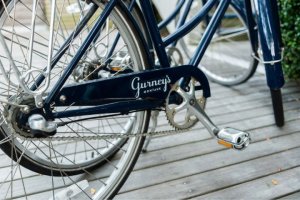 A close up of a navy blue beach cruiser bike with the Gurney's Montauk logo